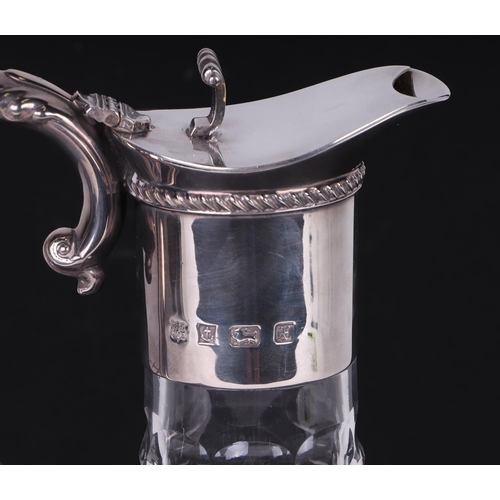 545 - A George III style claret jug with silver mounts, scroll thumbpiece and acanthus leaf capped scroll ... 