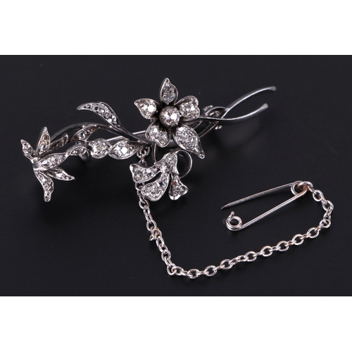 561 - A white metal diamond mounted floral spray and insect brooch, 5cms long, 8.1g.