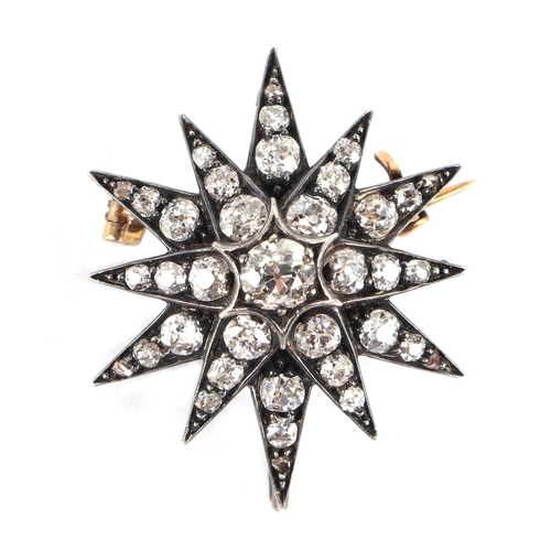 580 - A Victorian yellow and white metal mounted diamond set star brooch, 2.5cms diameter, the central dia... 