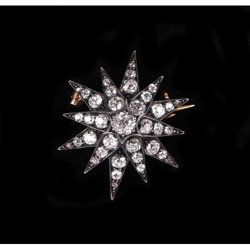 580 - A Victorian yellow and white metal mounted diamond set star brooch, 2.5cms diameter, the central dia... 