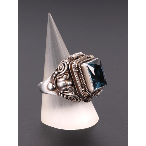 582 - A silver poison ring with single blue stone, approx UK size O.