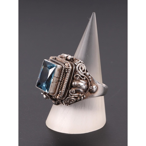 582 - A silver poison ring with single blue stone, approx UK size O.