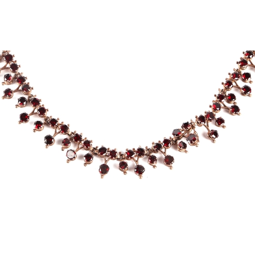 588 - A Victorian yellow metal mounted  garnet set necklace with 9ct gold clasp, 44cms long, 14.8g.