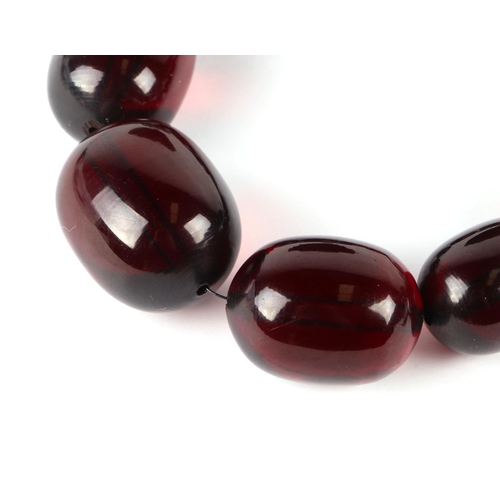 591 - A cherry amber Bakelite like graduated bead necklace, largest bead 3cms wide.