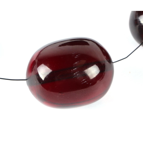 591 - A cherry amber Bakelite like graduated bead necklace, largest bead 3cms wide.