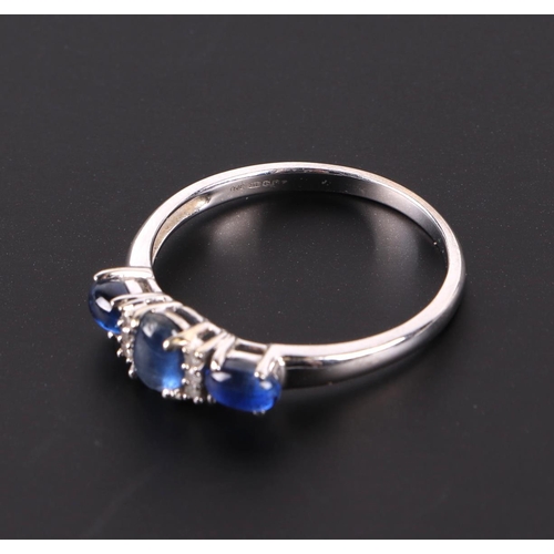 595 - A 9ct white gold ring set with three sapphire cabochons interspersed with small diamonds, approx UK ... 