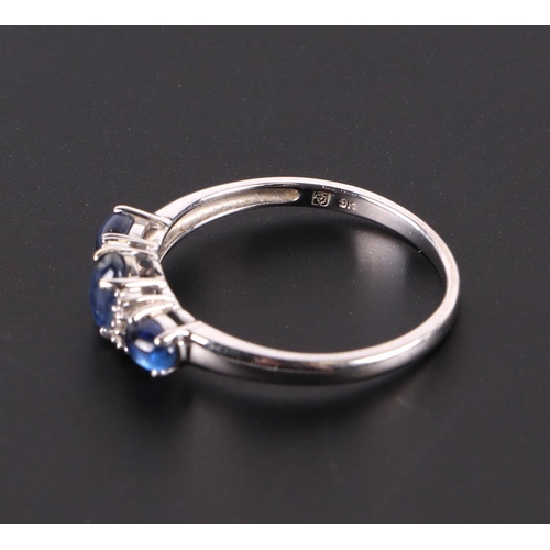 595 - A 9ct white gold ring set with three sapphire cabochons interspersed with small diamonds, approx UK ... 