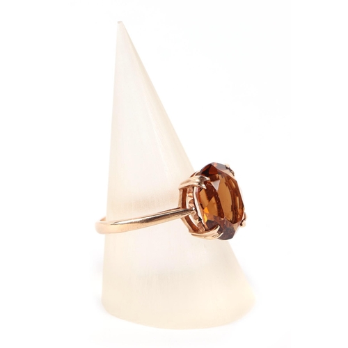 606 - A 9ct gold dress ring set with a large citrine, approx UK size O, 2.6g.