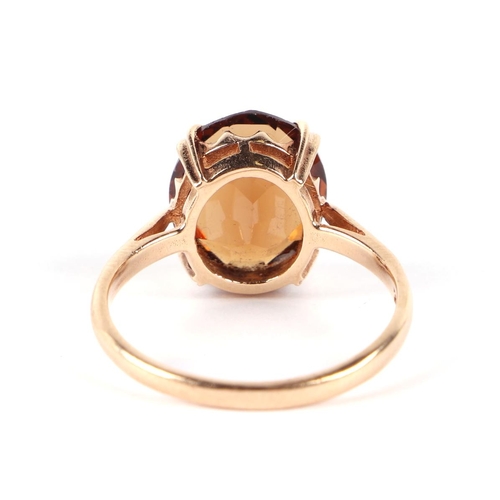 606 - A 9ct gold dress ring set with a large citrine, approx UK size O, 2.6g.