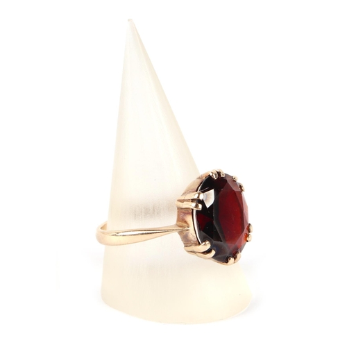 610 - A 9ct gold ring set with a large garnet, approx UK size R, 3.7g.