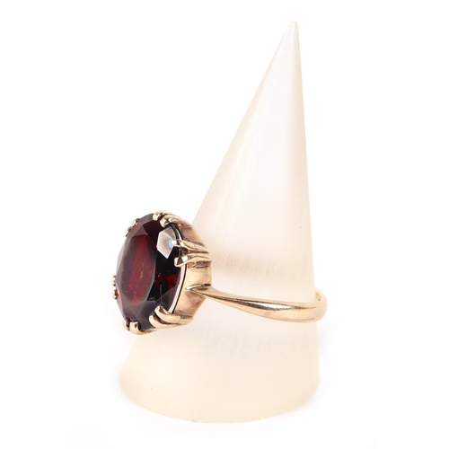 610 - A 9ct gold ring set with a large garnet, approx UK size R, 3.7g.