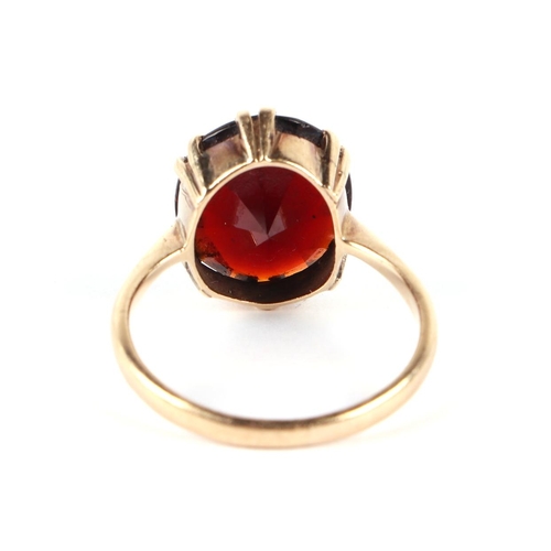 610 - A 9ct gold ring set with a large garnet, approx UK size R, 3.7g.