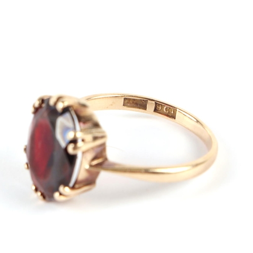 610 - A 9ct gold ring set with a large garnet, approx UK size R, 3.7g.