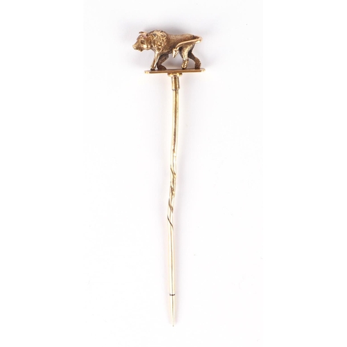 616 - A Victorian boxed yellow metal stick pin, the terminal in the form of a bull, 7cms high, 2.8g.