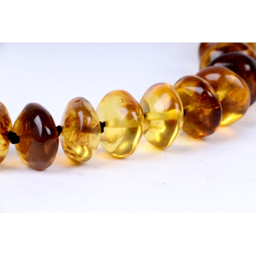 629 - A honey amber Bakelite bead necklace, largest bead approx 2.5cms wide, 69cms long.