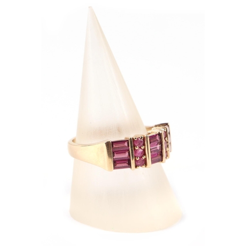 657 - A 9ct gold dress ring set with pale red stones, possibly rubies, approx UK size N, 3.3g.