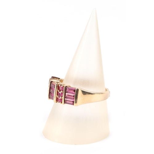 657 - A 9ct gold dress ring set with pale red stones, possibly rubies, approx UK size N, 3.3g.