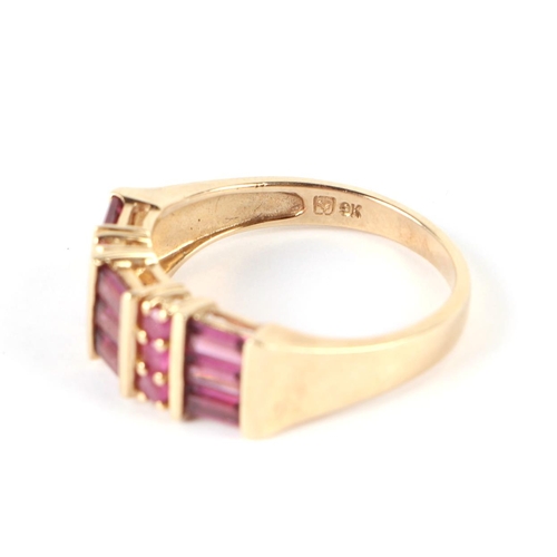 657 - A 9ct gold dress ring set with pale red stones, possibly rubies, approx UK size N, 3.3g.