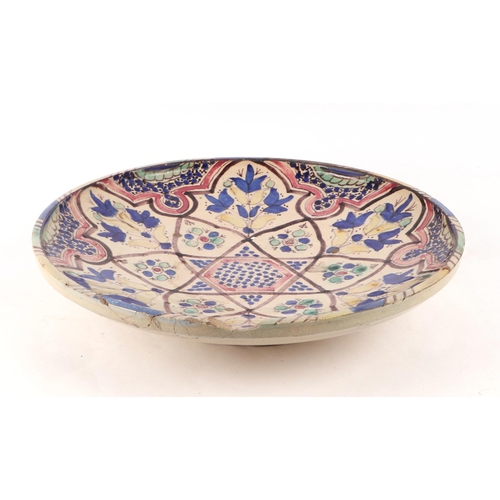 672 - A Palestinian glazed pottery bowl with traditional blue, red, green & yellow Iznik type decoration, ... 