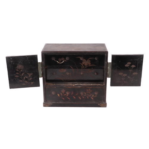 706 - A Japanese black lacquer table top cabinet, the pair of panelled doors opening to reveal two drawers... 