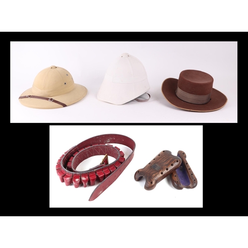 73 - A pith helmet; together with a red leather cartridge belt; two shotgun fore stock mounts; and other ... 