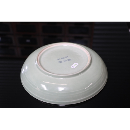 742 - A Chinese celadon glaze shallow dish, with six character blue marks to the underside, 26cm diameter,... 