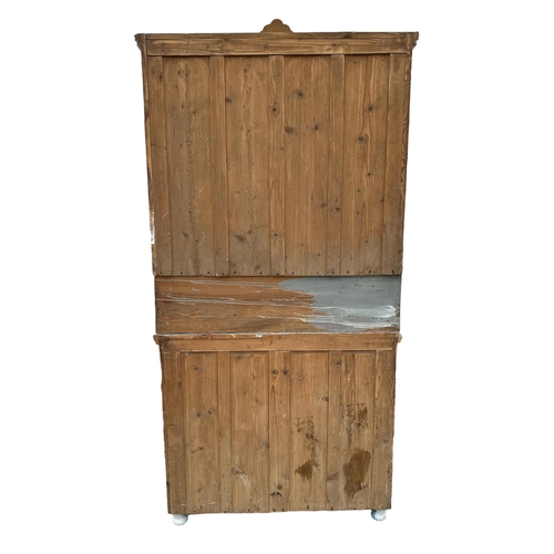 802 - A continental distressed painted pine dresser, the pair of glazed doors enclosing a shelved interior... 