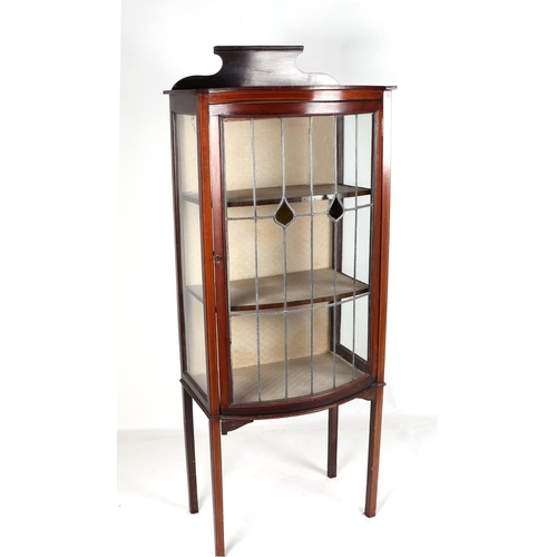 841 - An Edwardian mahogany bowfront display cabinet, the leaded glass panelled door enclosing a shelved i... 