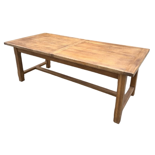 846 - A large oak refectory table, the rectangular top inset with two extra leaves, on chamfered square le... 