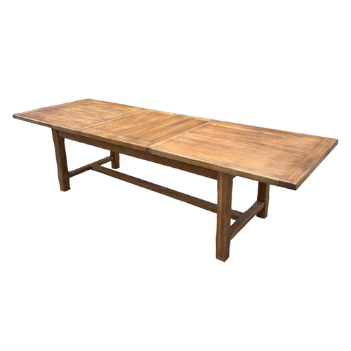 846 - A large oak refectory table, the rectangular top inset with two extra leaves, on chamfered square le... 