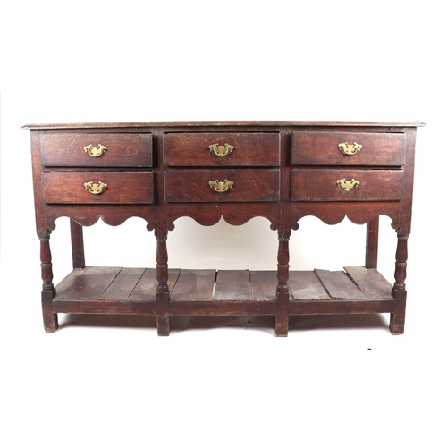 858 - A 19th century oak dresser base with an arrangement of six drawers above a shaped apron and pot boar... 