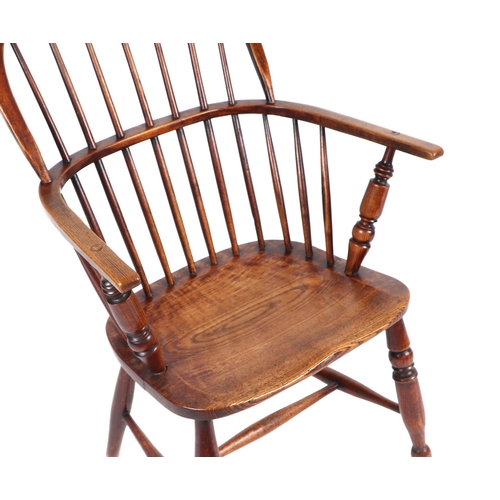 875 - A 19th century elm Windsor armchair on turned legs joined by an 'H' stretcher.