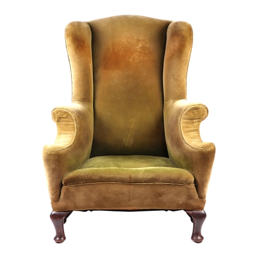 879 - A wingback armchair on dwarf cabriole front legs joined by a stretcher.