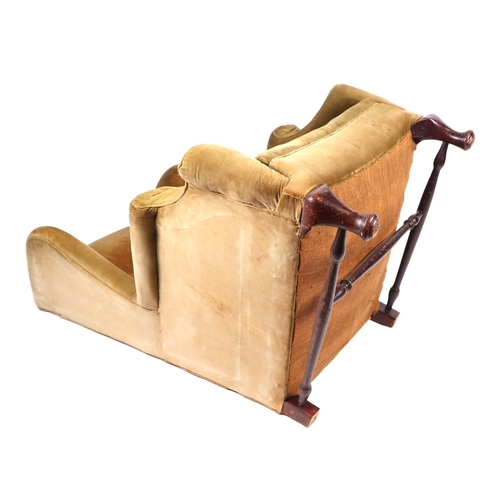 879 - A wingback armchair on dwarf cabriole front legs joined by a stretcher.