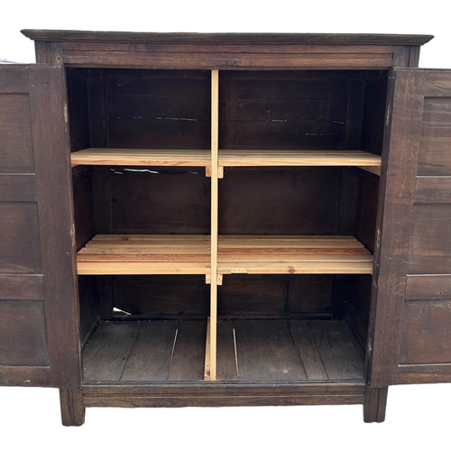 905 - An 18th / 19th century oak livery cupboard, the pair of panelled doors enclosing a shelved interior,... 