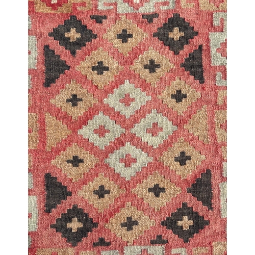 96 - A kilim rug with repeating geometric pattern on a pink ground, 102 by 89cms.