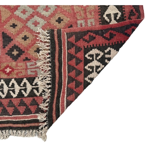 96 - A kilim rug with repeating geometric pattern on a pink ground, 102 by 89cms.