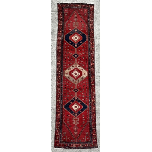 99 - A Persian hand knotted Hamadan runner of geometric design with three central medallions and stylised... 