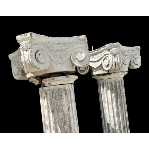 895 - A large pair of distressed painted pine Corinthian columns, 243cms high (2).