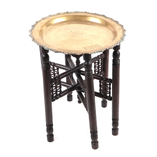 783 - A brass tray-top table on folding stand, 58cms diameter; together with another similar smaller, on a... 