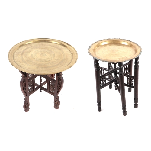 783 - A brass tray-top table on folding stand, 58cms diameter; together with another similar smaller, on a... 