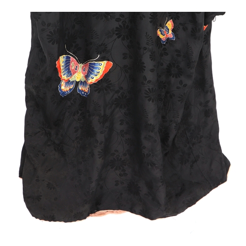 703 - A Japanese silk robe decorated with butterflies on a black ground.