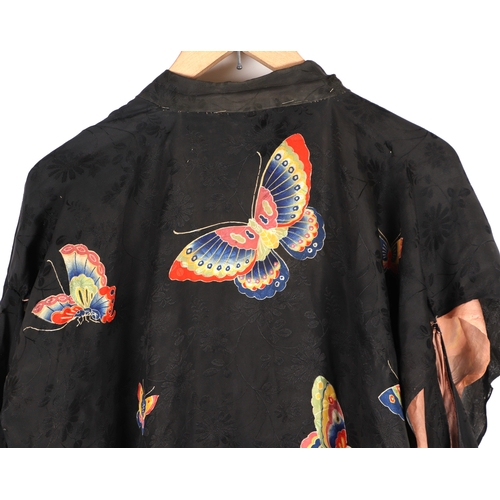 703 - A Japanese silk robe decorated with butterflies on a black ground.