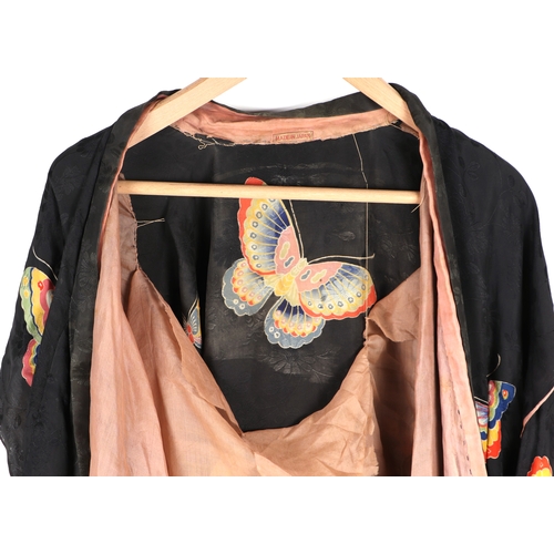 703 - A Japanese silk robe decorated with butterflies on a black ground.