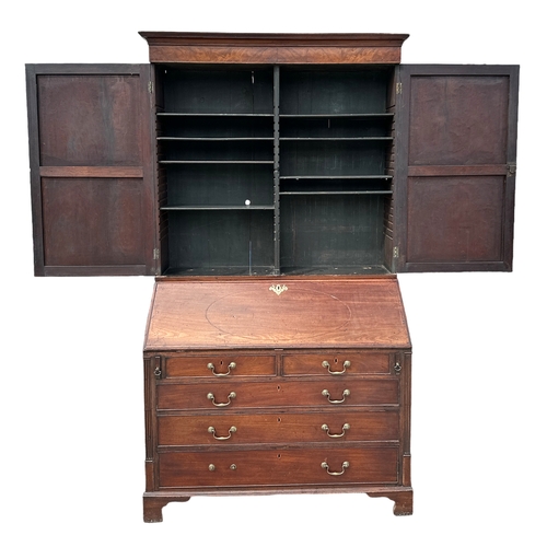 838 - A Georgian mahogany bureau bookcase, the pair of panelled doors enclosing a shelved interior above a... 