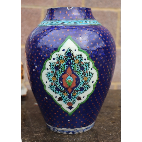 687 - A Palestine / Iznik pottery vase decorated with stylised flowers on a blue ground, 28cms high.