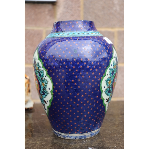 687 - A Palestine / Iznik pottery vase decorated with stylised flowers on a blue ground, 28cms high.