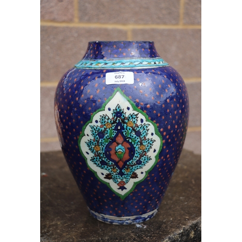 687 - A Palestine / Iznik pottery vase decorated with stylised flowers on a blue ground, 28cms high.