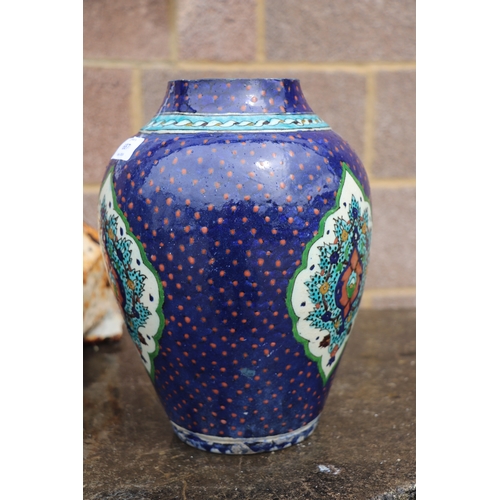 687 - A Palestine / Iznik pottery vase decorated with stylised flowers on a blue ground, 28cms high.