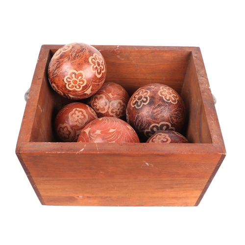 233 - A quantity of assorted ceramic carpet type balls in a wooden box.